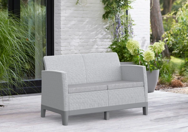 Popielato-szara sofa 2-osobowa Scandi Forma na szarej podstawie, widok z przodu na tarasie.