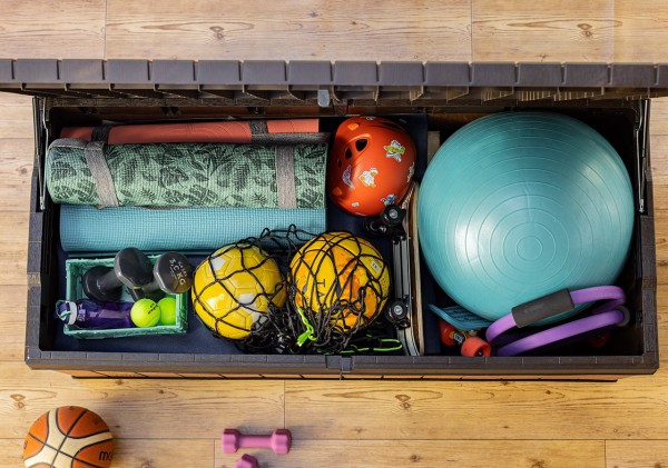 Otwarta brązowa skrzynia ogrodowa Darwin z góry, wypełniona sprzętem sportowym i akcesoriami.
